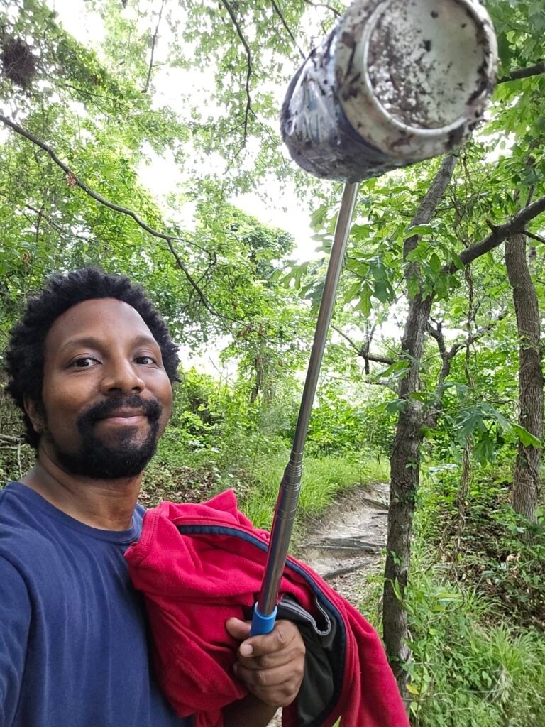 RJ, leader of 757 Uplifters, holding an empty can with an extendable rod that has a hook!